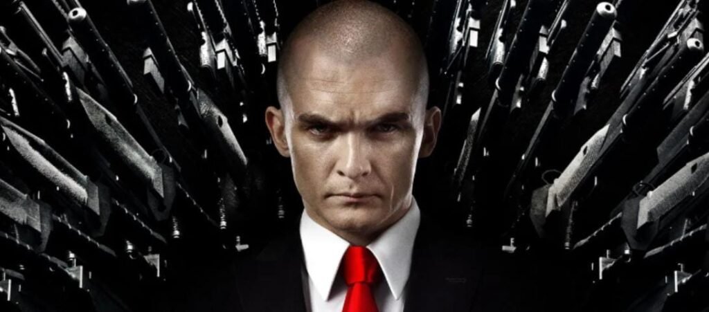 স্মার্ট ব্লেজার পরা একজন কপালচেরা এজেন্ট, পেছনে অসংখ্য অস্ত্রের ভয়ঙ্কর ব্যাকগ্রাউন্ড